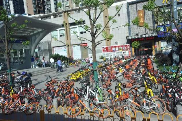 武汉街头大批量共享单车将地铁站团团包围。